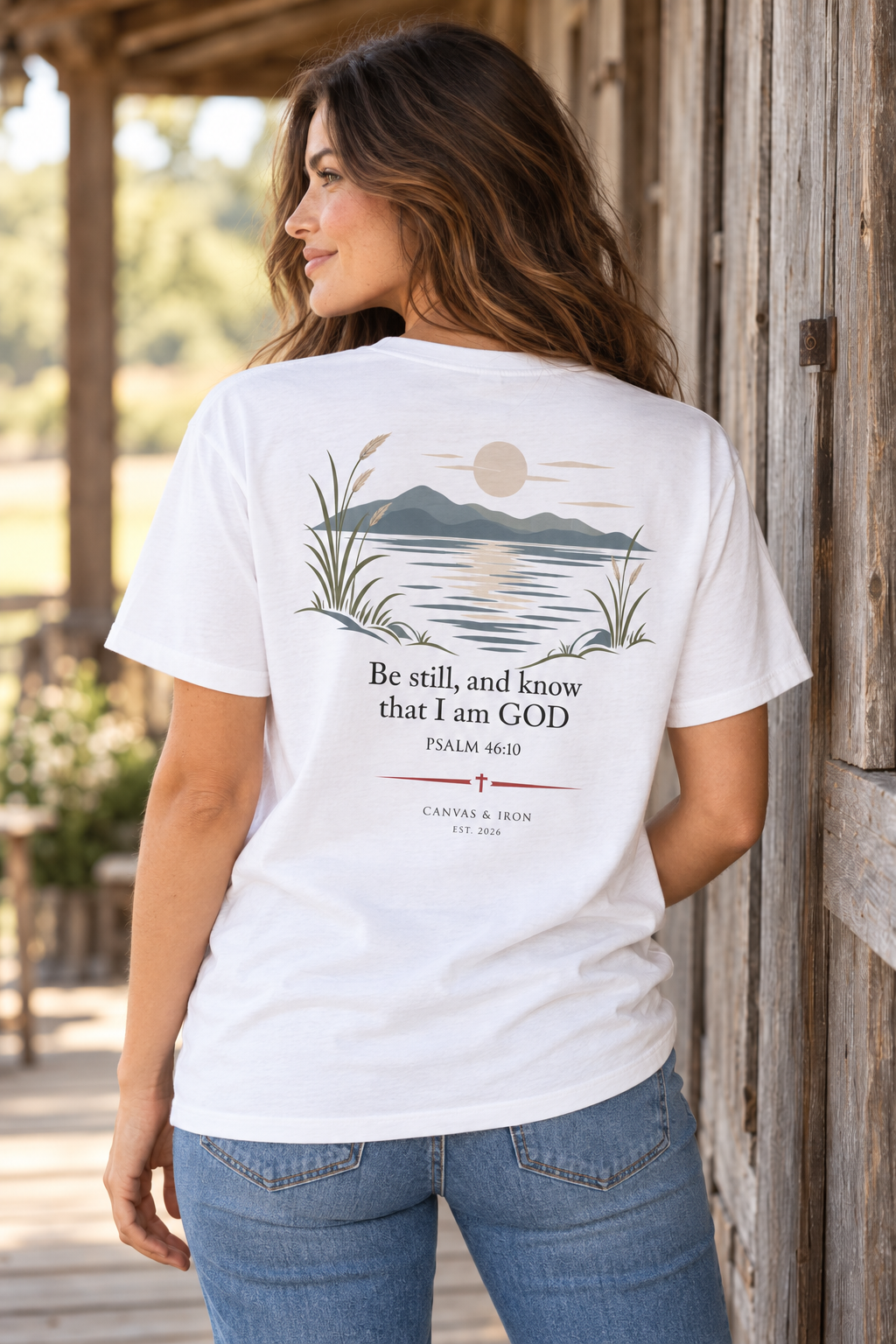 Back of Be Still women’s faith tee with Psalm 46:10 waterside landscape artwork