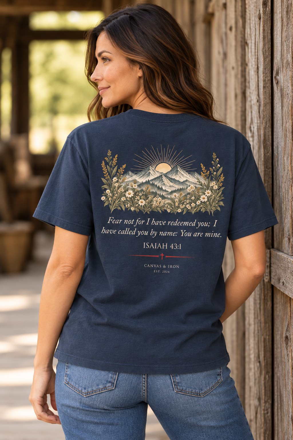 Back of Redeemed women’s faith tee with Isaiah 43:1 mountain and wildflower artwork